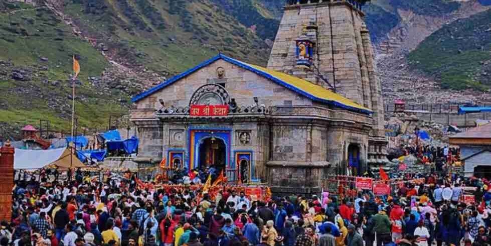 Pilgrims gathered at Kedarnath Temple, with the Himalayas rising in the background beneath cloudy skies.